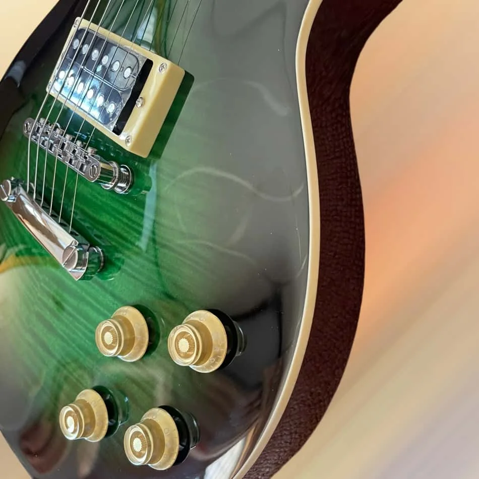 

39-inch black-bound green electric guitar with trapezoid inlays on a rosewood fingerboard, mahogany body, 2 pickups, and silver