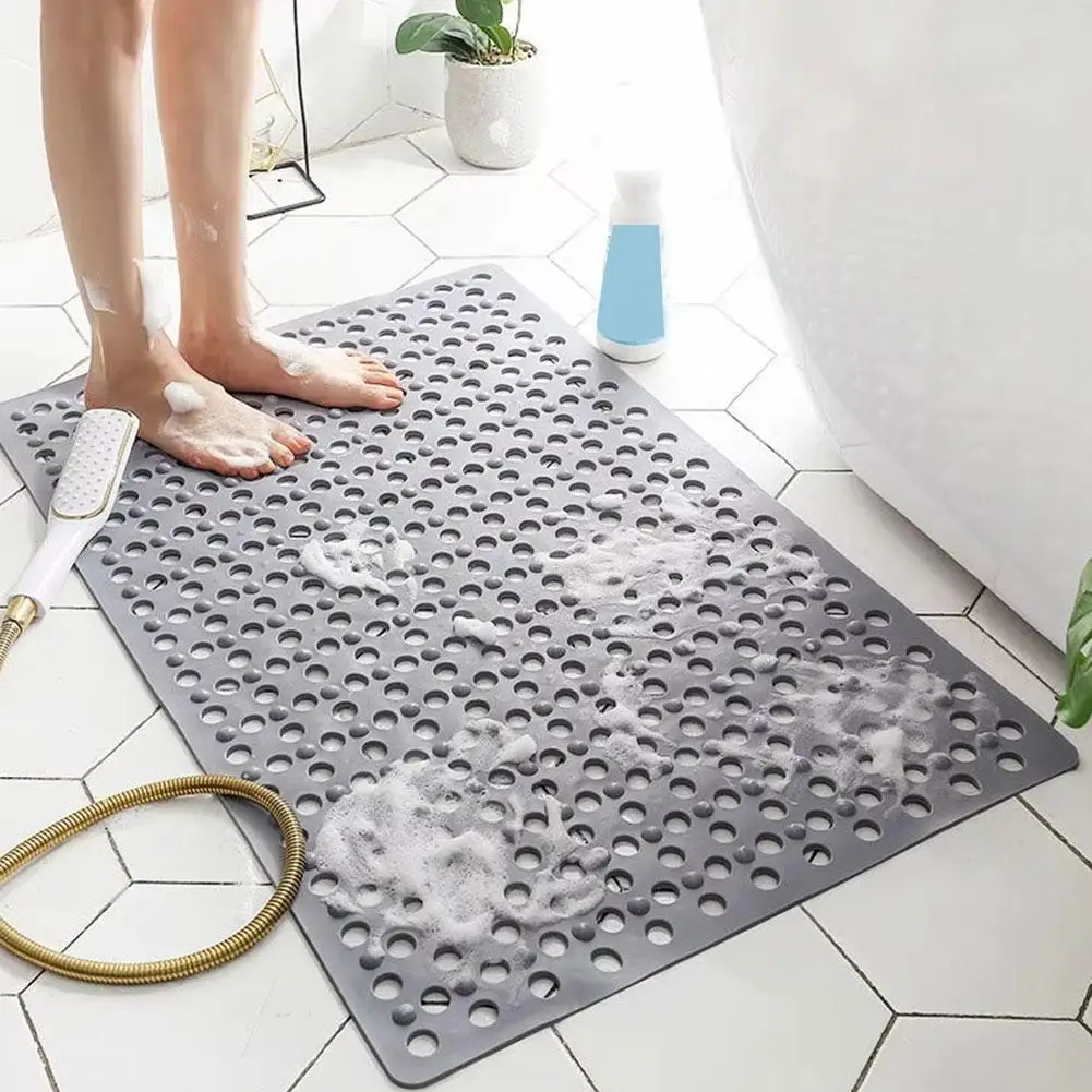 Blue 3D bath mat with suction cups and massage bumps on wet floor.