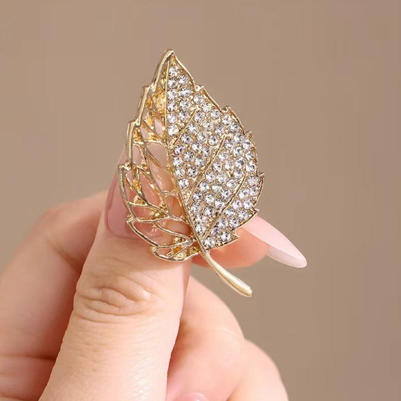 بروش فاخر مرصع بالألماس المتلألئ على شكل أوراق ذهبية يفتح نمط أنيق رائع يعرض الملمس الراقية ورائع