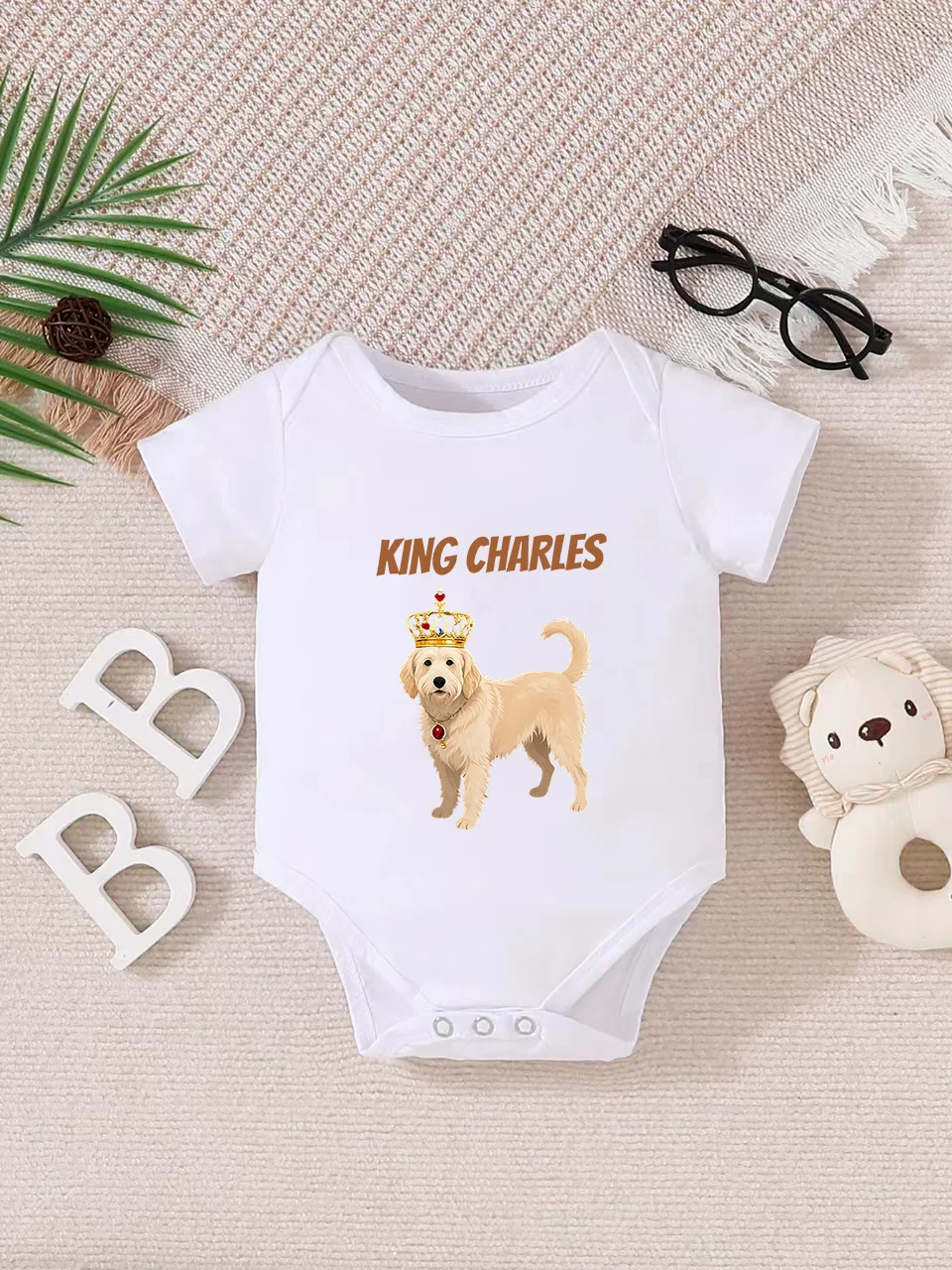 Playful letter-printed baby short-sleeve triangle bodysuit. Button closure for easy dressing, machine washable