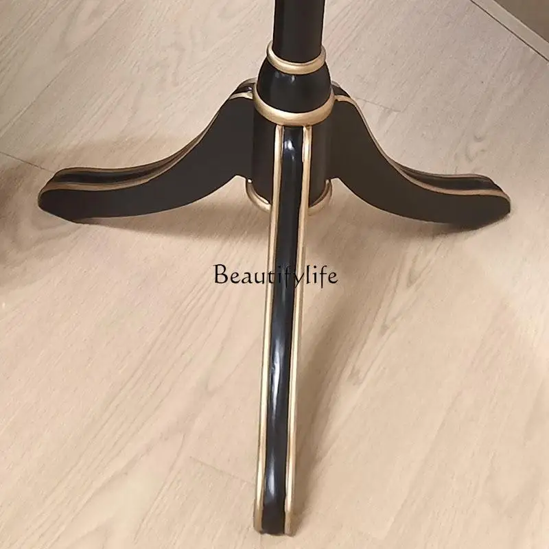 **โต๊ะกลมเล็กทาสีมือสไตล์อเมริกันในชนบท โซฟาไม่กี่มุมในห้องนั่งเล่น และโต๊ะกลมไม่กี่ตัว