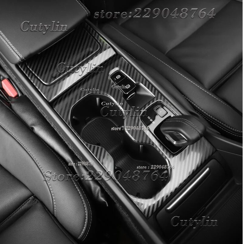 Kit de molduras interiores Volvo XC40 de fibra de carbono 2019-2021 con moldura de consola central con textura de fibra de carbono, acentos de cuero negro y portavasos integrados.
