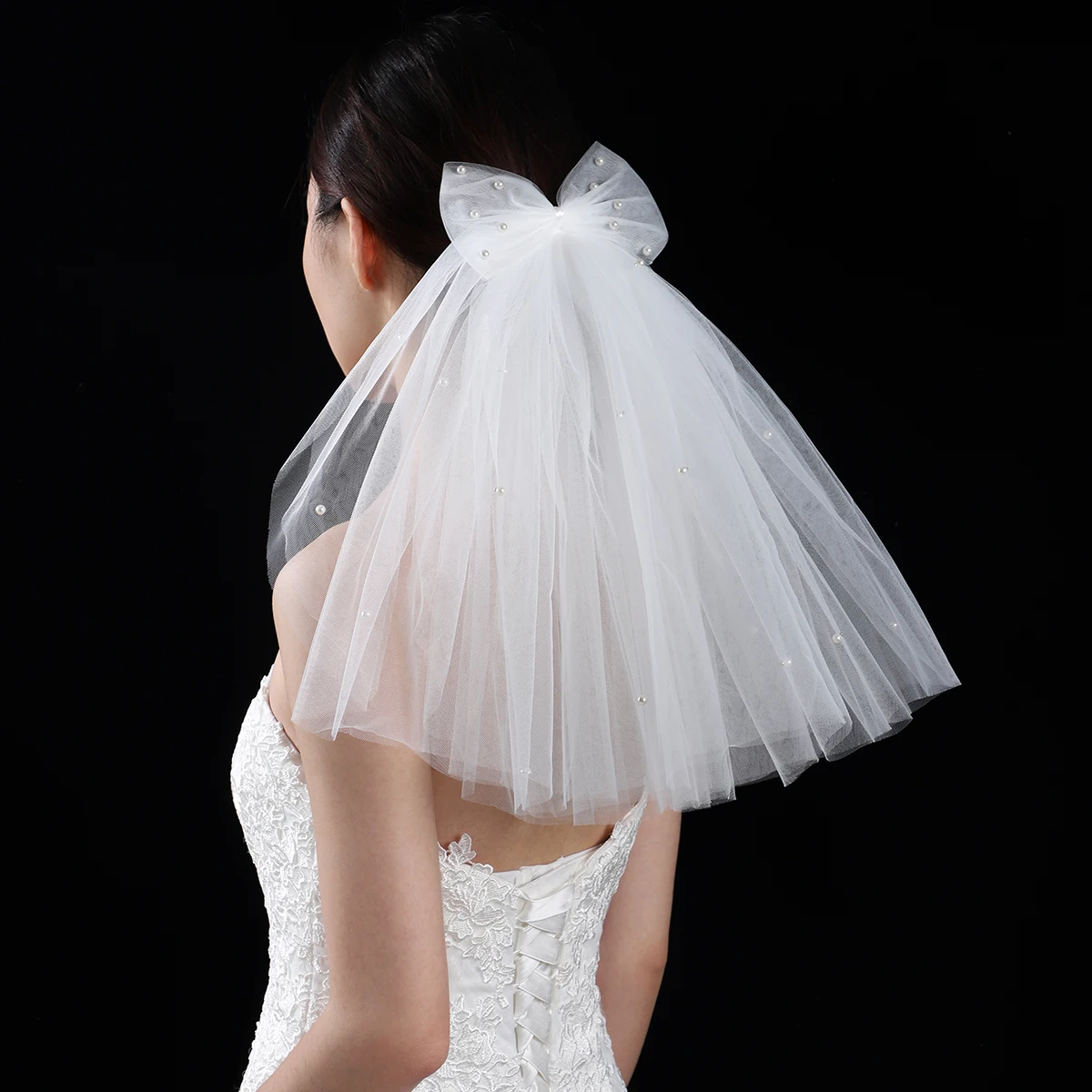 A white elegant bridal veil adorned with a simple bow, shoulder length veil suitable for women's weddings