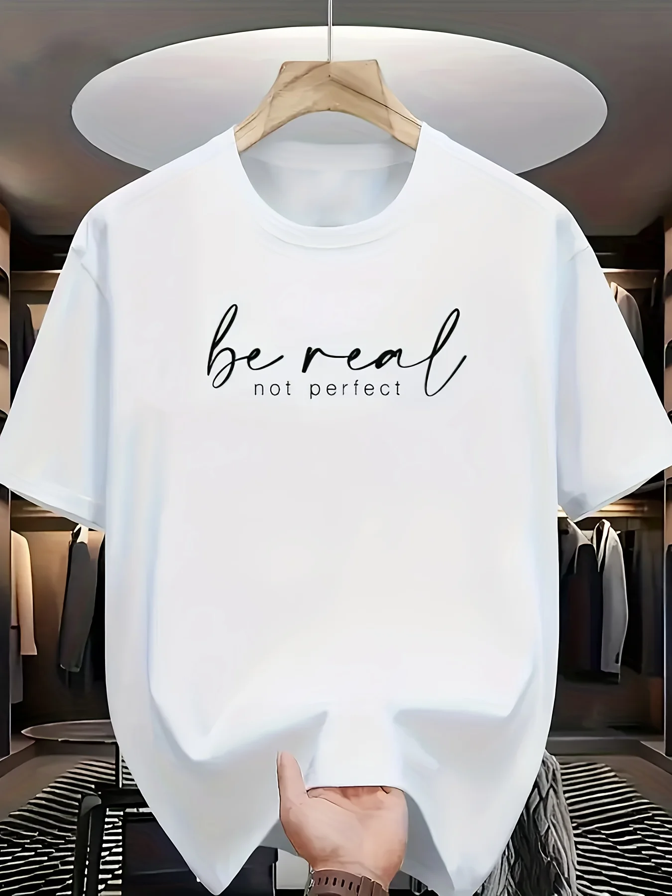 Weißes Kurzarm-T-Shirt in Kleiderschrank-Szene: Mit schwarzem „be Real Not Perfect“-Aufdruck auf der Brust, kombiniert minimalis
