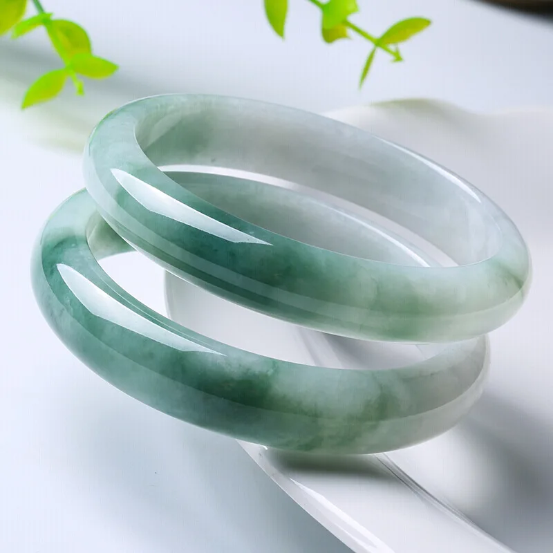 Milk-colored  semi-gloss green jadeite bracelet  with greenish hue and a smooth  round shape