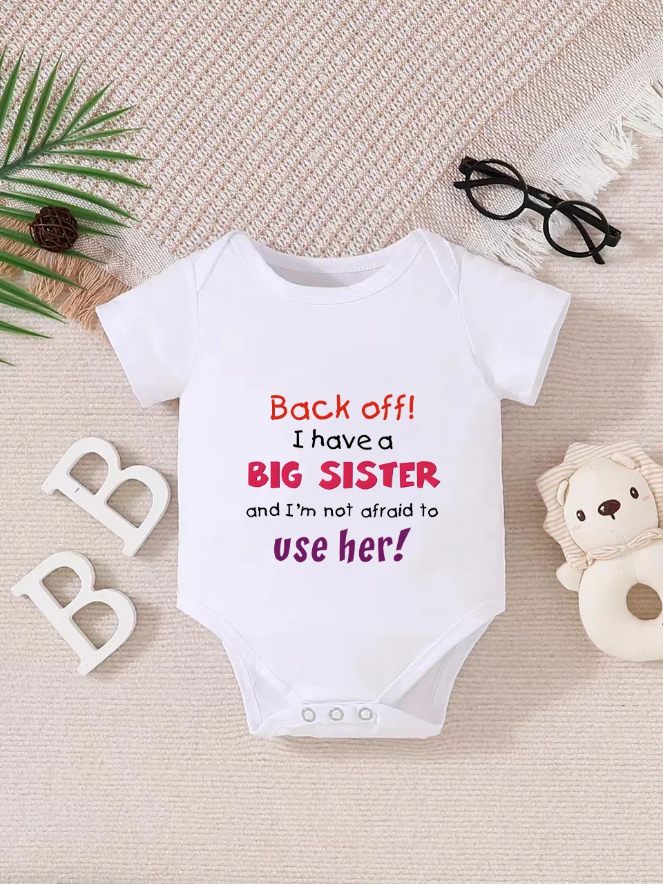 Playful letter-printed baby short-sleeve triangle bodysuit. Button closure for easy dressing, machine washable