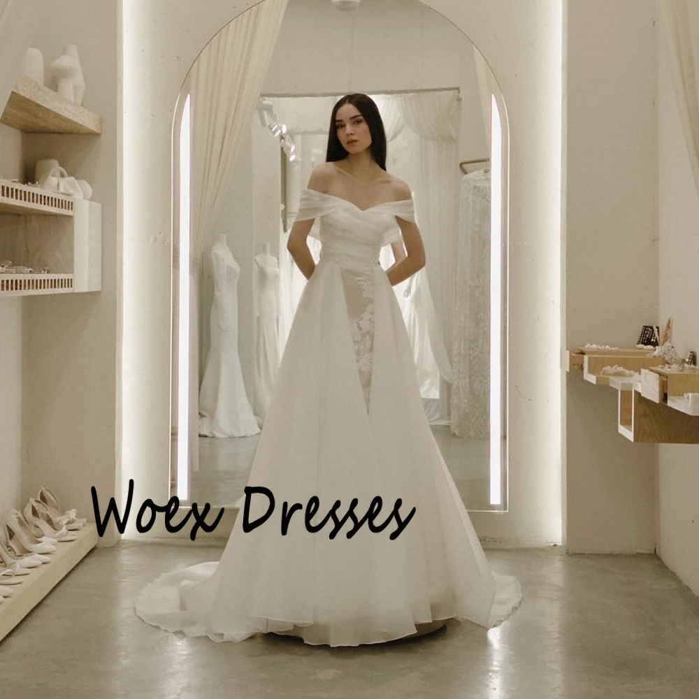 Suknia ślubna z organzy w kolorze białym, z odkrytymi ramionami, aplikacjami, trenem Watteau, odkryte plecy, fason A-line, długość do podłogi.