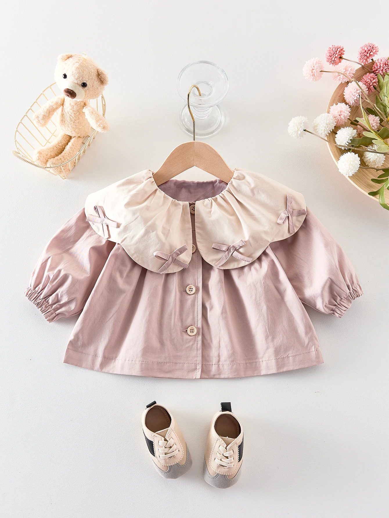 

For autumn and winter, the baby girl is wearing a long-sleeved, large lapel long-sleeved top with a bow, a cute and sweet little