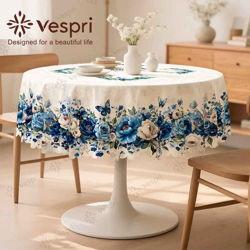 Vespri Spring Tablecloth, featuring white and blue patterns, with butterflies, flowers and green leaves.