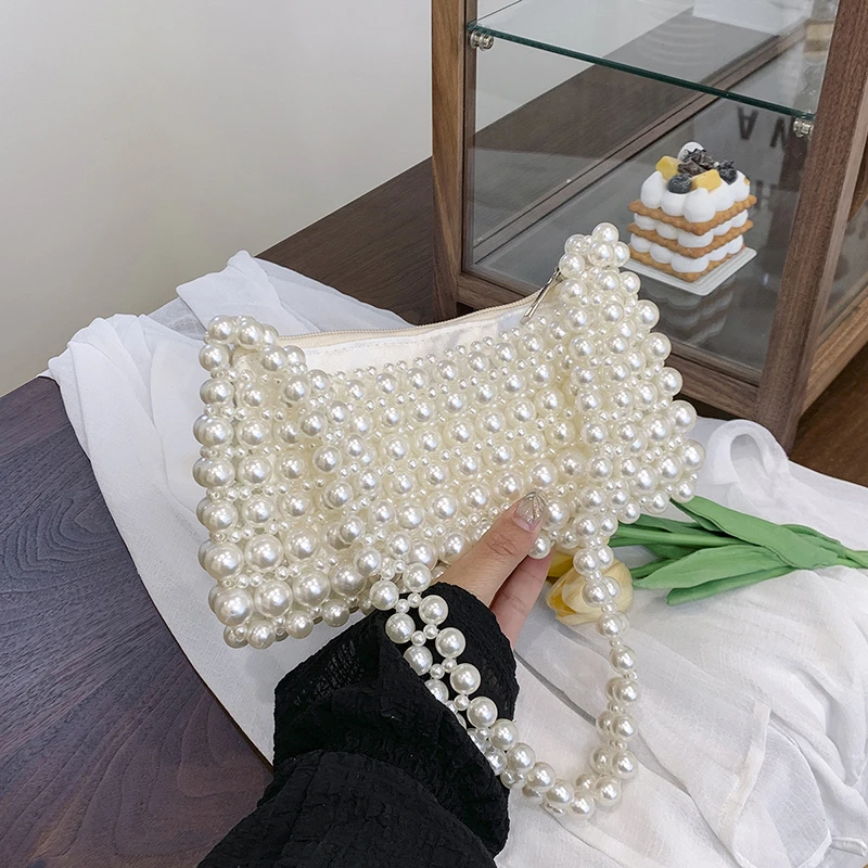 

Летние универсальные модные женские сумки на плечо с жемчугом под мышками, новинка 2025 года, полые сумки большой вместимости, лаконичные сумки для поездок на работу