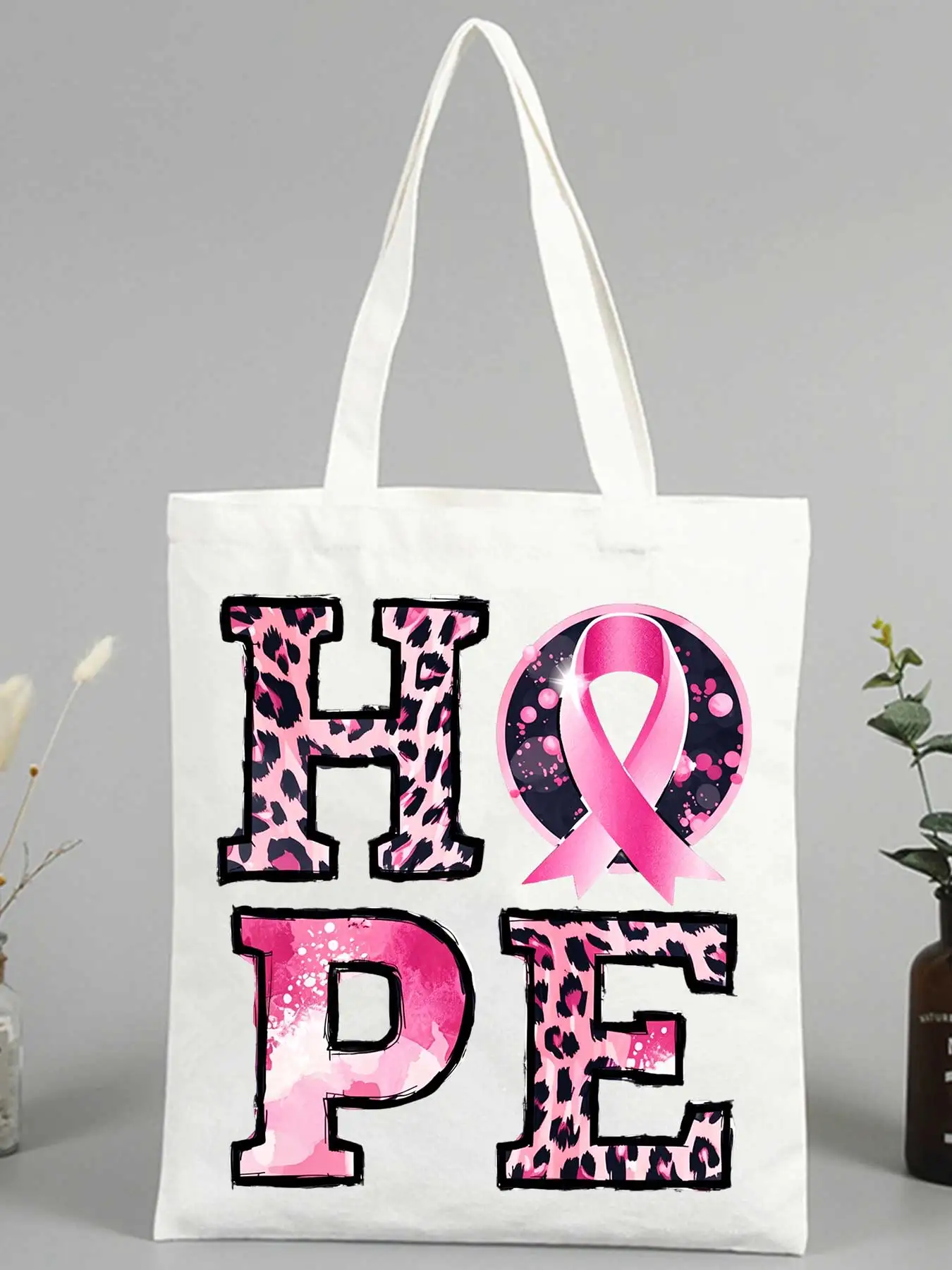 Women's canvas tote bag with leopard print and pink ribbon graphic, ideal for casual daily use and awareness events