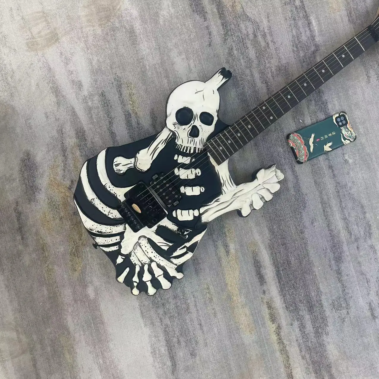 

Skull style electric guitar with 6-string split body, black body, matte color, rose wood fingerboard, open pickup, tremolo pull