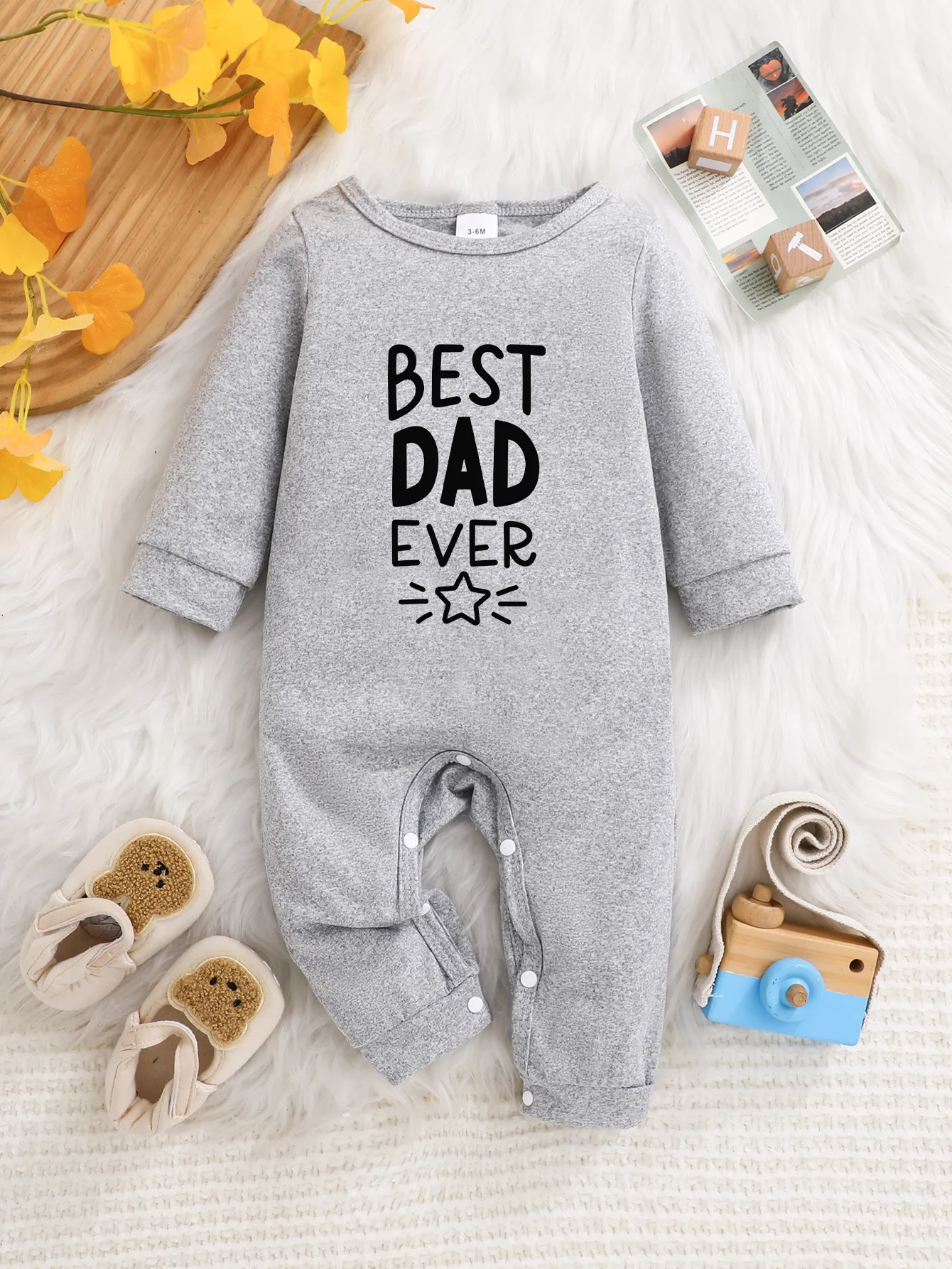 A baby long-sleeved onesie with interesting letter prints. It features a buttoned design for easy putting on and taking off, and