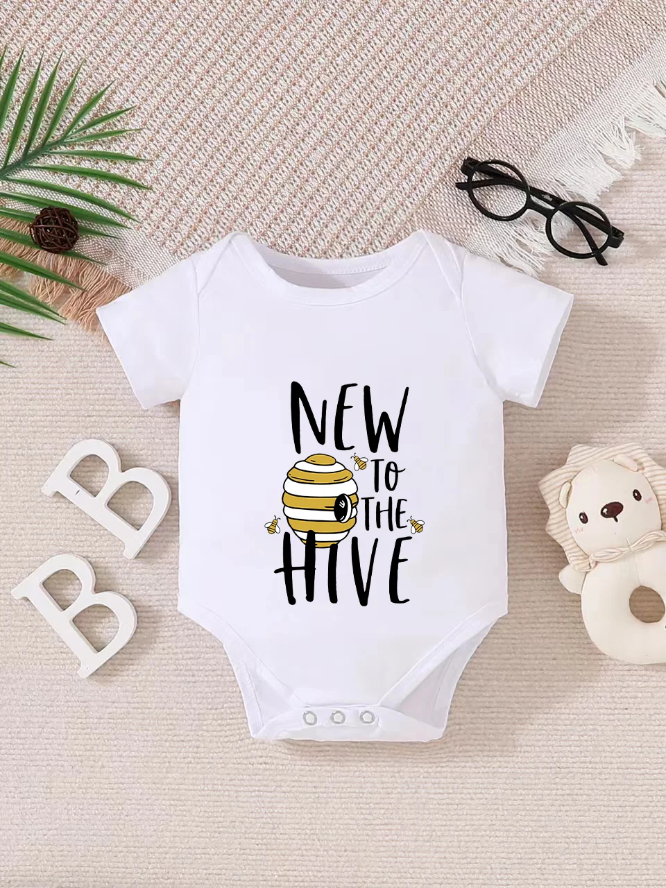 Playful letter-printed baby short-sleeve triangle bodysuit. Button closure for easy dressing, machine washable