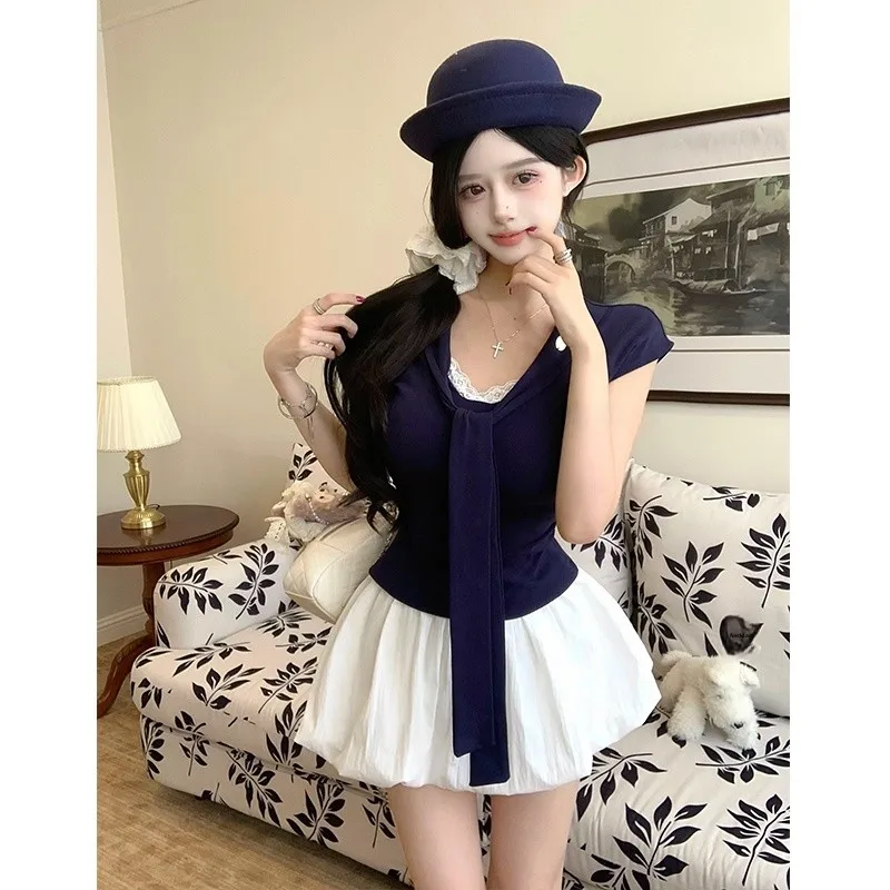 

Шикарный повседневный комплект из двух предметов: футболка с темно-синим воротником и кружевными вставками, облегающие шорты-юбка. Модный летний женский наряд.