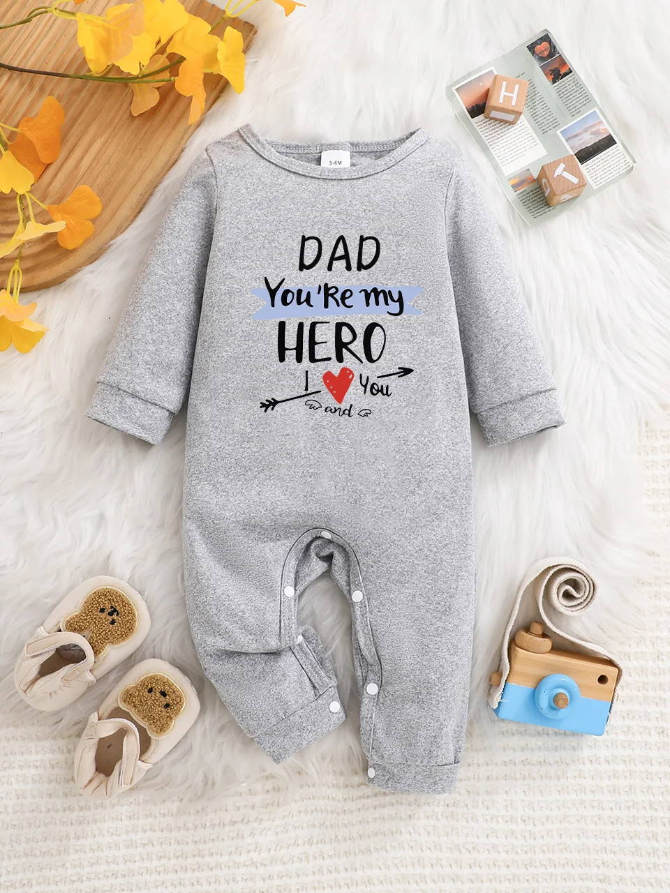 A baby long-sleeved onesie with interesting letter prints. It features a buttoned design for easy putting on and taking off, and
