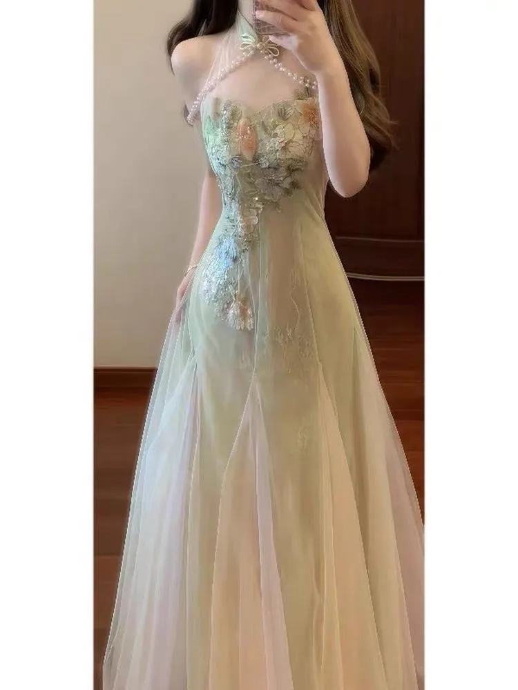 Deze mooie en unieke jurk met bloemenhalslijn straalt een zachte elegante charme uit. Het is voorzien van netgaas-patchwork met tailleband