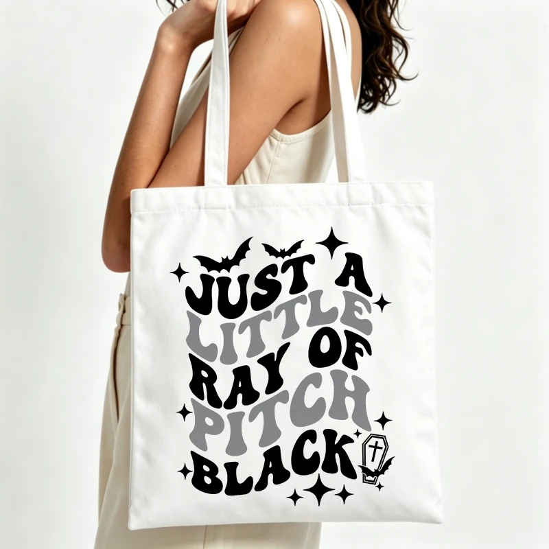 Halloween-themed canvas tote bag with bat and typography print, perfect for casual autumn outings and seasonal shopping