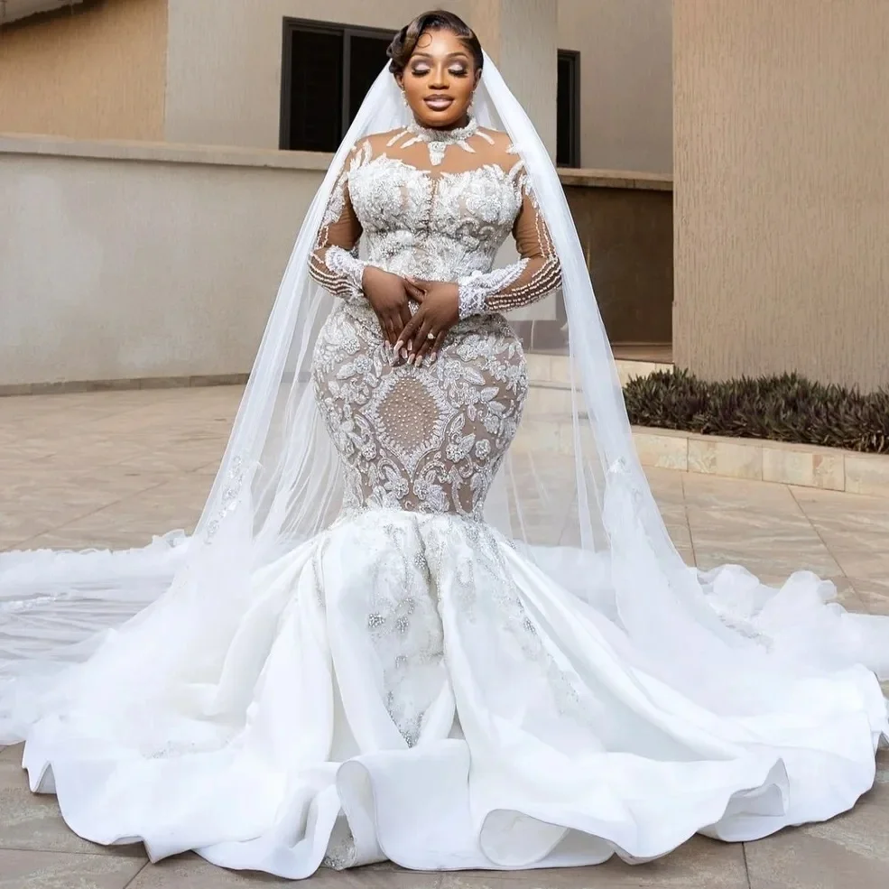 

Индивидуальное свадебное платье с высоким воротником, расшитое блестящими бусинами и пайетками, с длинными рукавами и застежкой на пуговицы сзади.