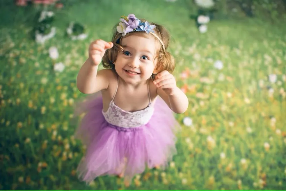 Fondos de primavera del país de las Maravillas para fotografía flores blancas árbol grande pradera verde princesa bebé niña feliz fondo de fotografía de Pascua
