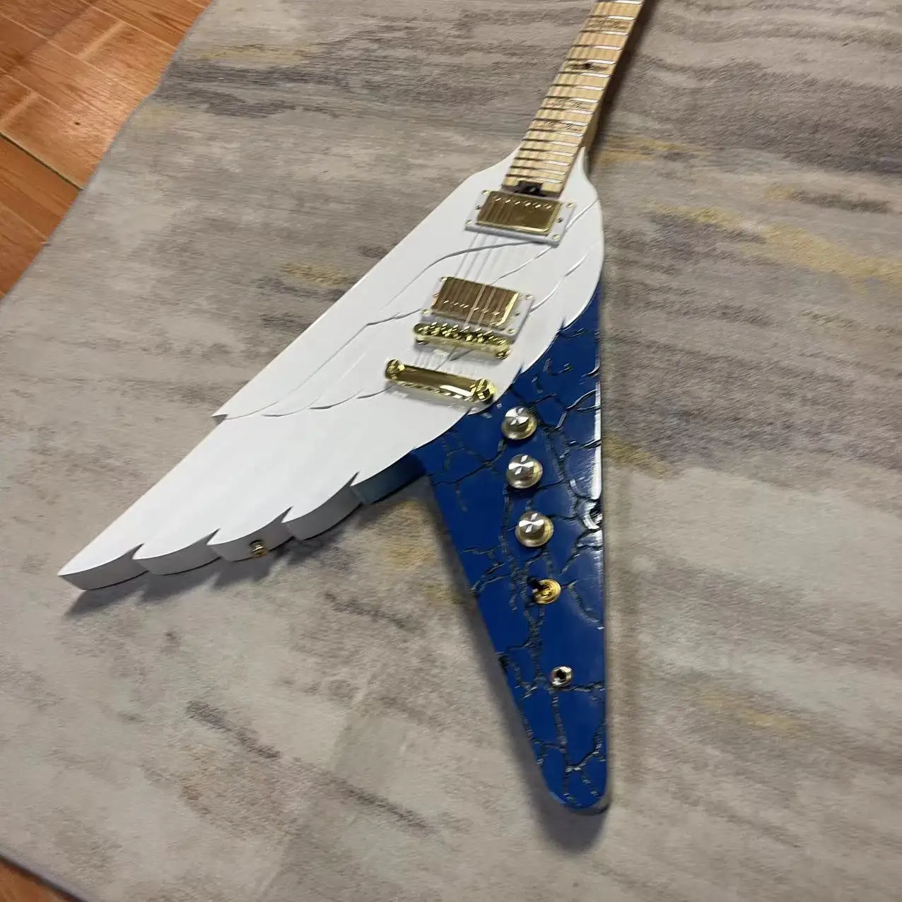 In stock, the carved version of the Freedom Wing electric guitar is available with a white body and gold accessories. Real photo