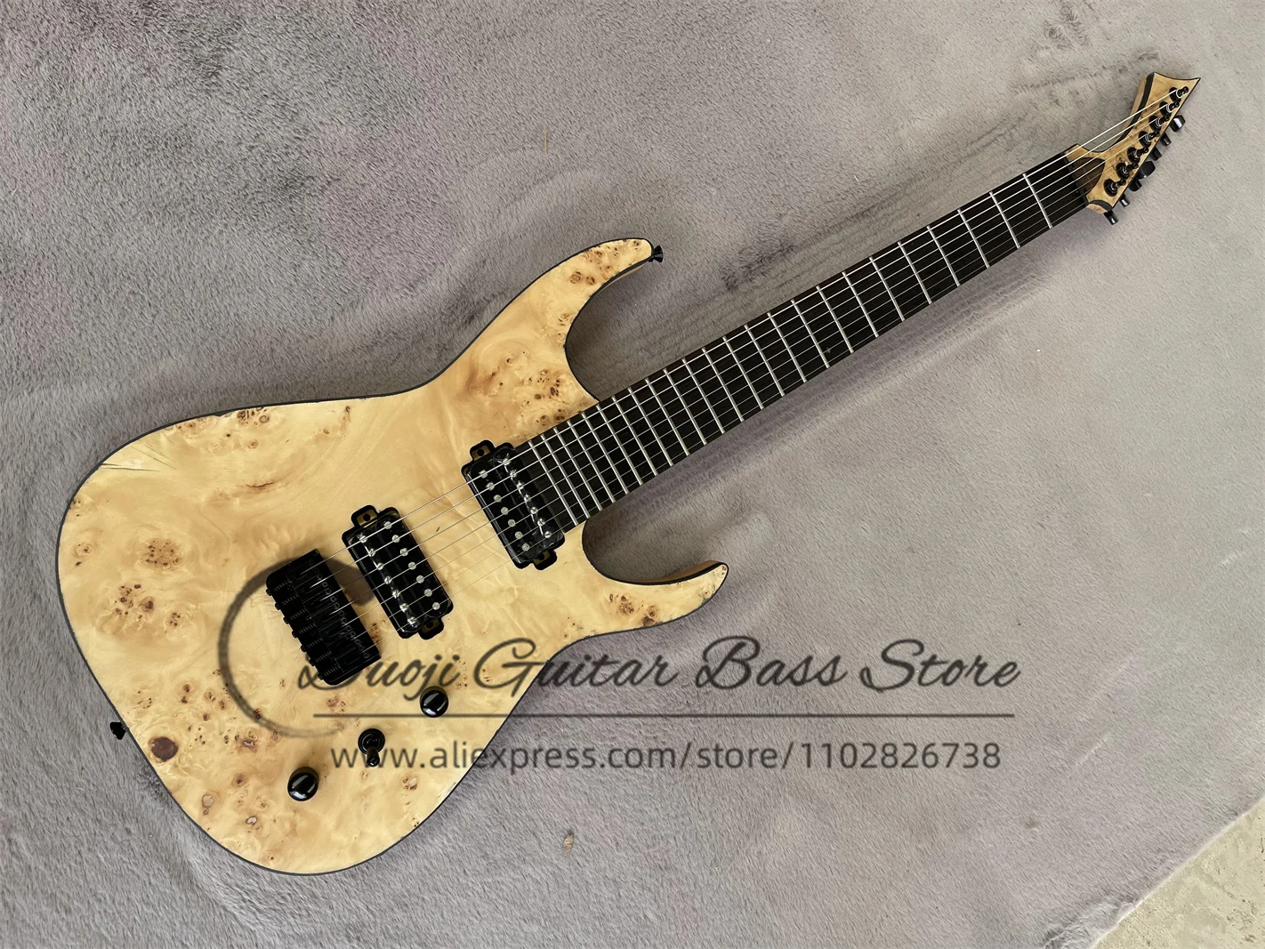 

7-струнная гитара с корпусом из ясеня, верхней декой из кленового шпона, черной окантовкой, фиксированным бриджем, черными тюнерами, натуральным покрытием и звукоснимателями HH.