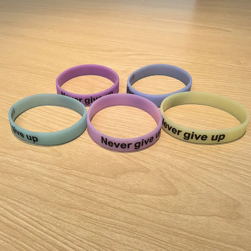 سوار معصم من السيليكون المتوهج في الظلام مع طباعة "لا تتخلى أبدًا" - سوار رياضي تحفيزي، مريح ومتين، متعدد C