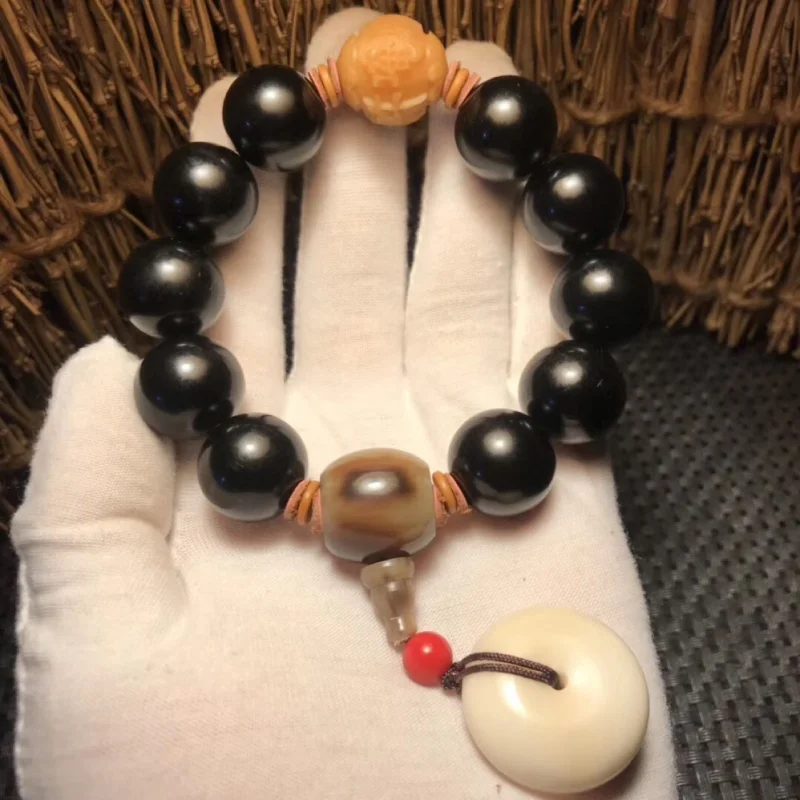 Natural black ox bracelet with weathered Bodhi beads, six-character mantra, ox horn connector, and ivory fruit peace pendan