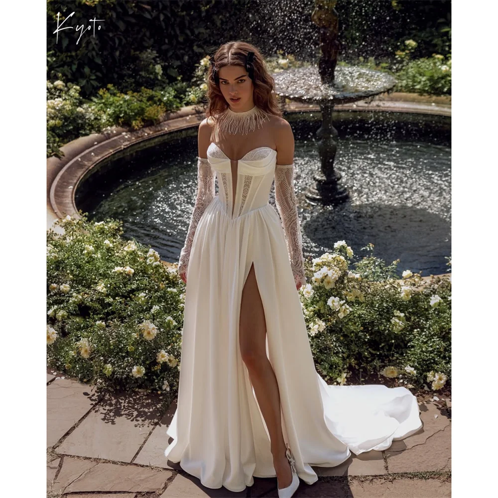 ชุดแต่งงานสีไอวอรี่แบบสั่งตัดพิเศษจากโคจิโอ คอวีเว้าลูกไม้ แขนยาวผ่าข้างสูง กระโปรงทรงเอไลน์ ชายกระโปรงยาวแบบทีร์เทรน สำหรับงานพิธีการ