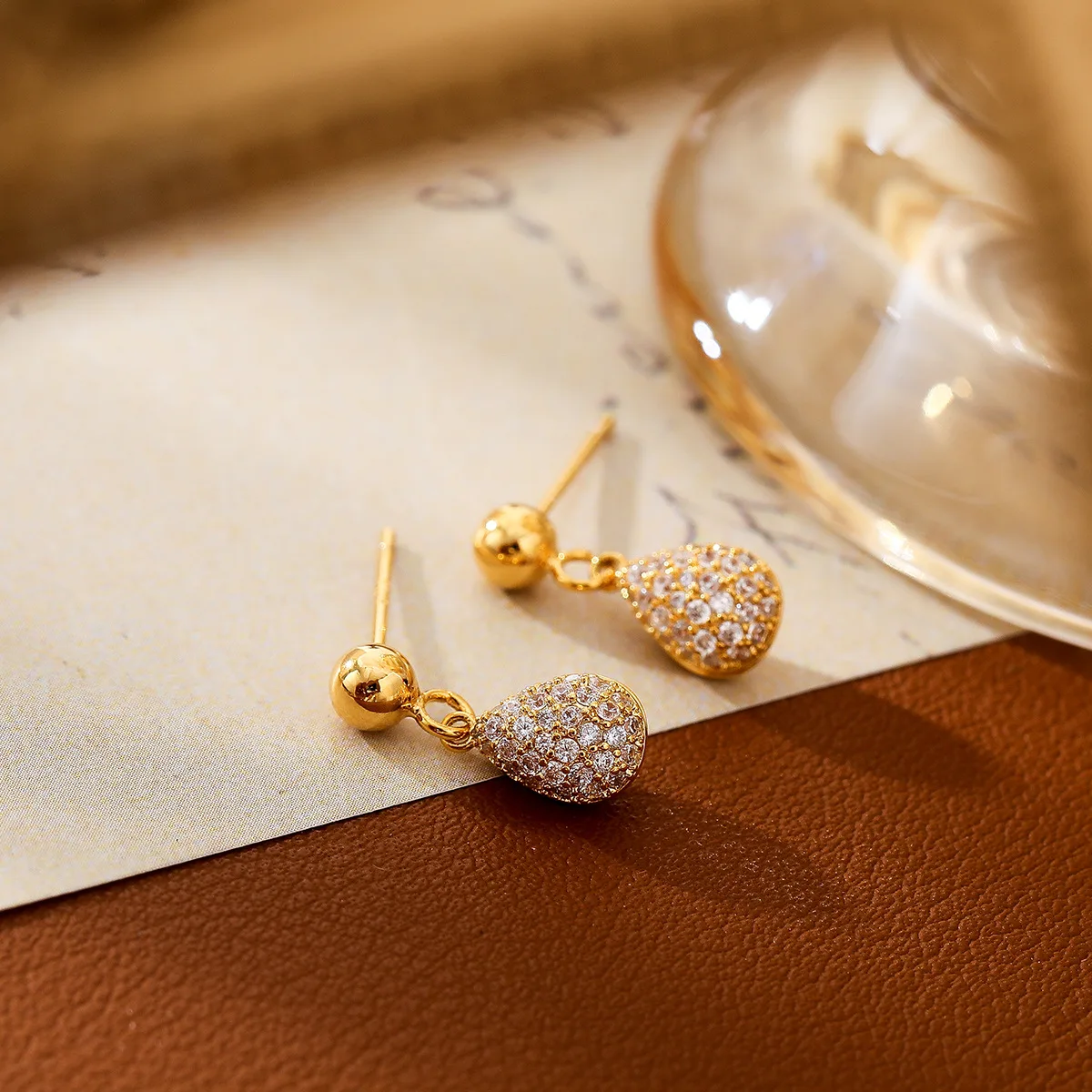 Pendientes estilo francés con microincrustaciones de circonio y colgante de forma de calabacín, con aguja de plata bañada en oro y cobre.
