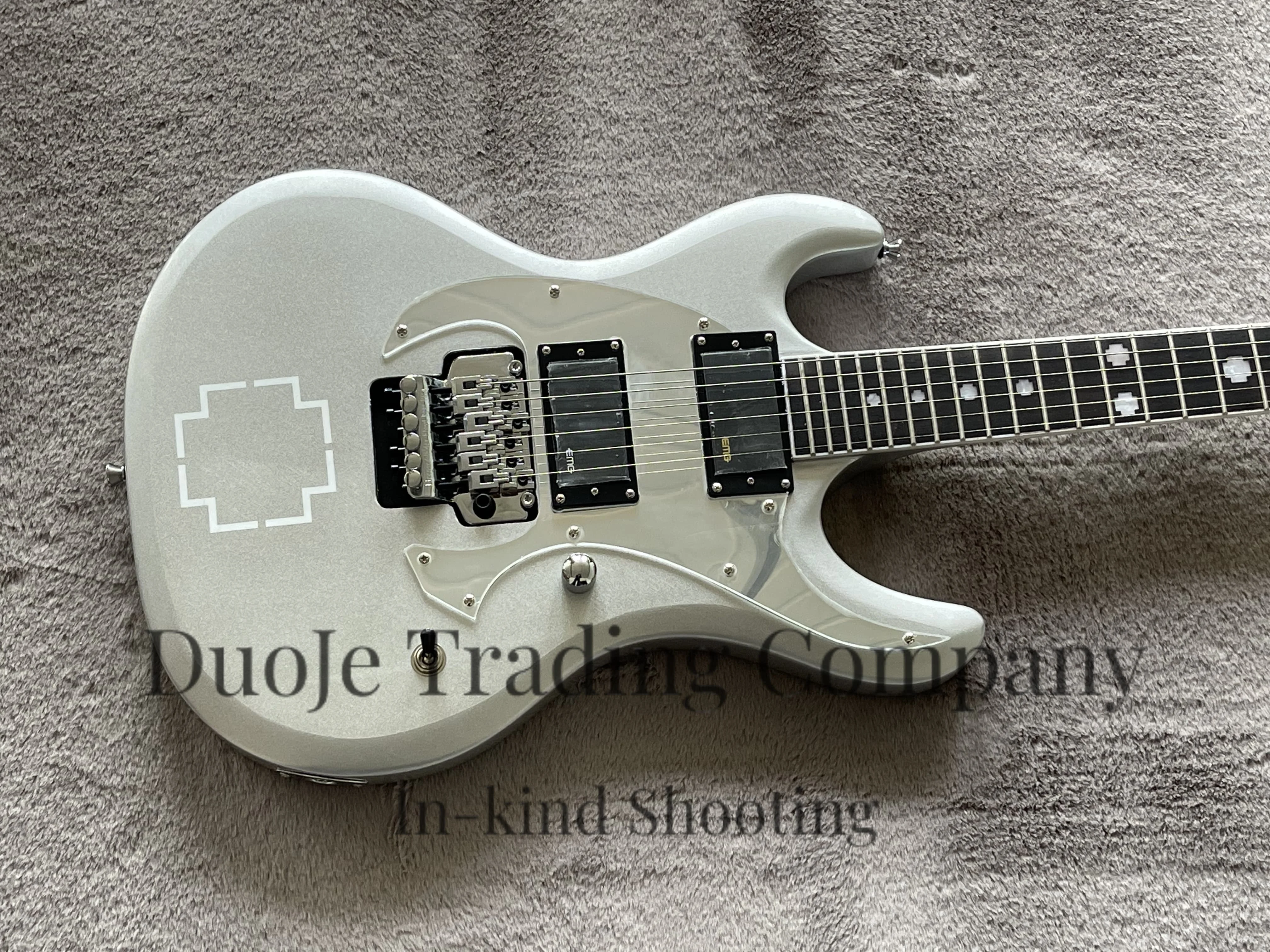 Silver guitar with Tremolo bridge, Maple neck set in body, Rosewood fingerboard with cross pearl inlays, Mirror pickguard
