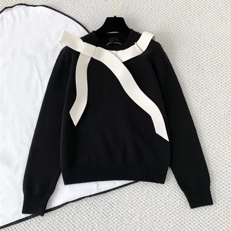 

Индивидуальная европейская и американская женская одежда на зиму 2025. Вязаный свитер с длинными рукавами и круглым вырезом с черным бантом.
