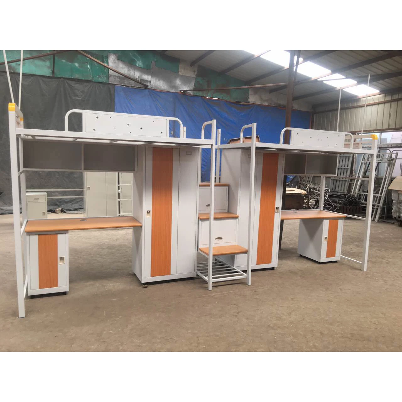 เตียงสองชั้นเหล็กสำหรับนักเรียนในหอพักพร้อมโต๊ะเขียนหนังสือและโต๊ะทำงานสำหรับผู้ใหญ่