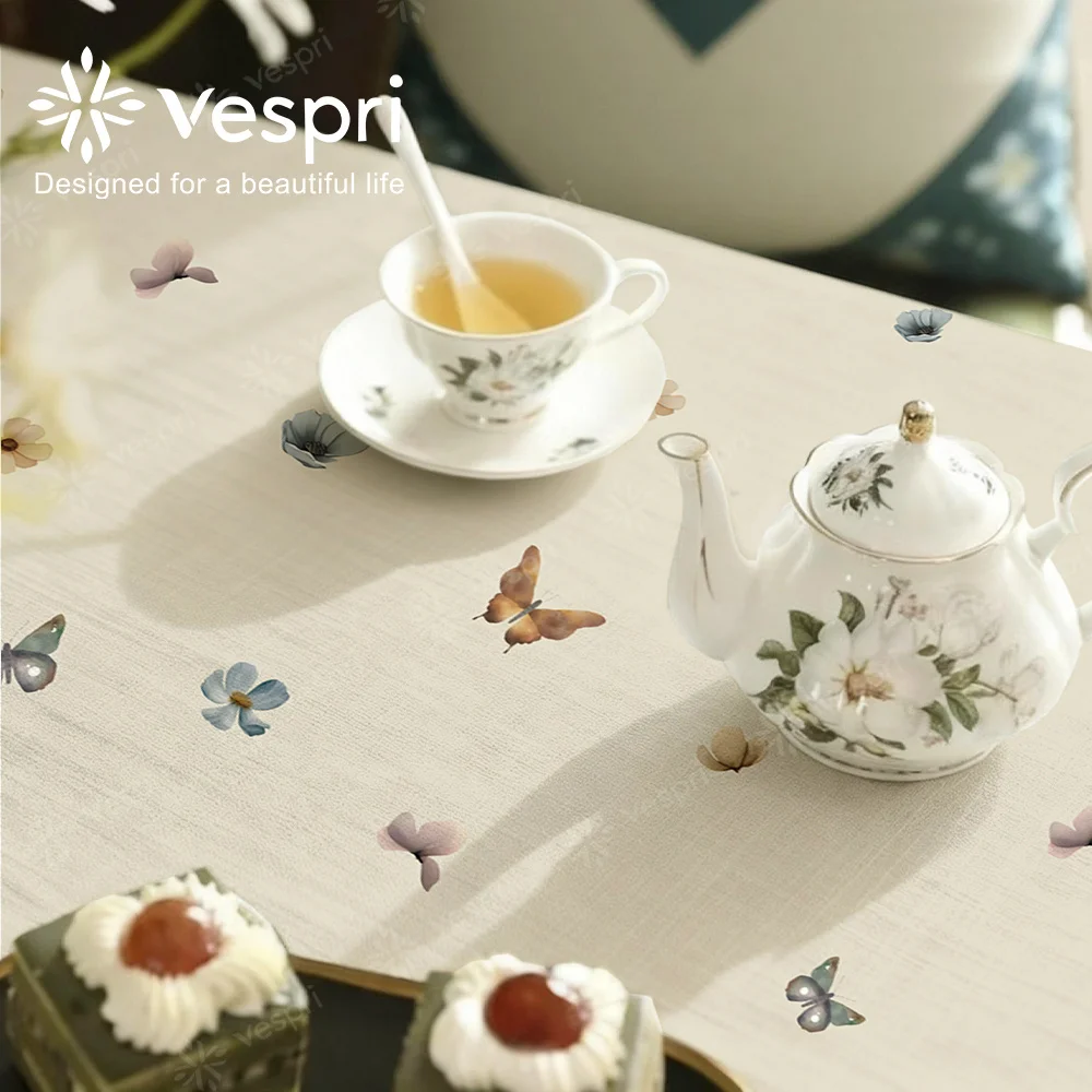 Vespri Spring Tablecloth, featuring white and beige patterns, with butterflies and flowers, in a contemporary style.