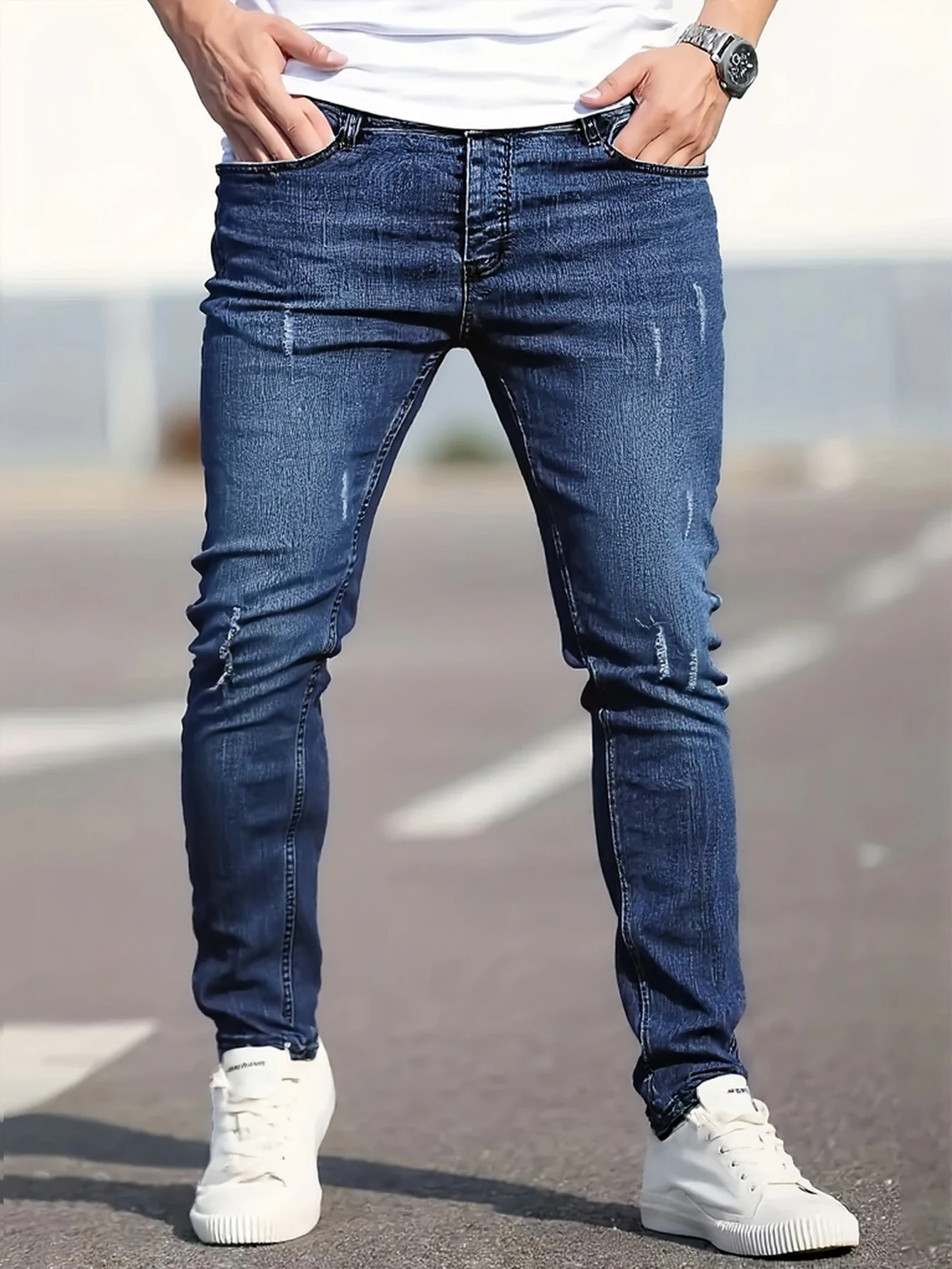 

Men's slim-fit blue jeans with subtle distressing, contouring to the body, effortlessly creating a casual and trendy style.