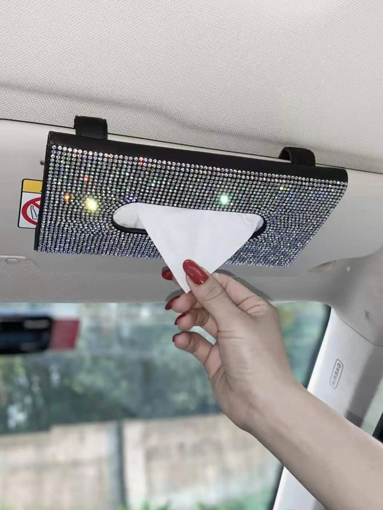 

Glamorous sun visor tissue box adorned with sparkling rhinestones. It features fine workmanship, easy clip-on installation and stable fixation. This practical storage holder keeps tissues within reach while adding a luxurious and stylish touch