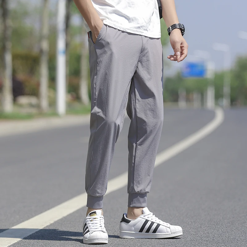 Wysokiej jakości nowa marka casualowe modne elastyczne spodnie dresowe z paskami, długie, ołówkowe, młodzieżowe, dopasowane, szybkoschnące spodnie męskie.