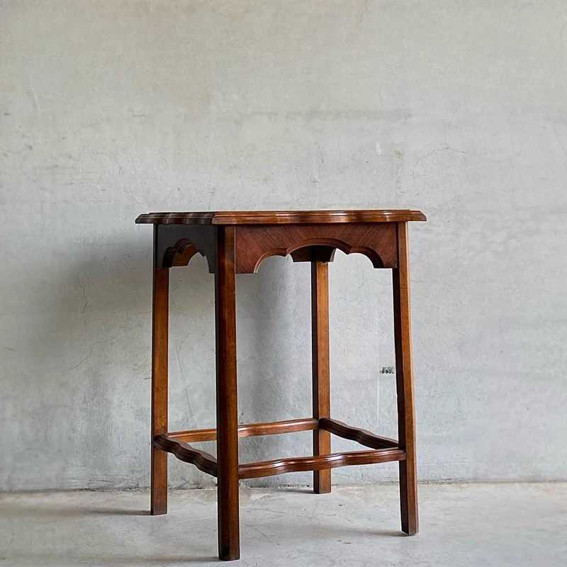 

Solid wood retro edge with a few porches to make old bedside table decorated with flowers against the wall.