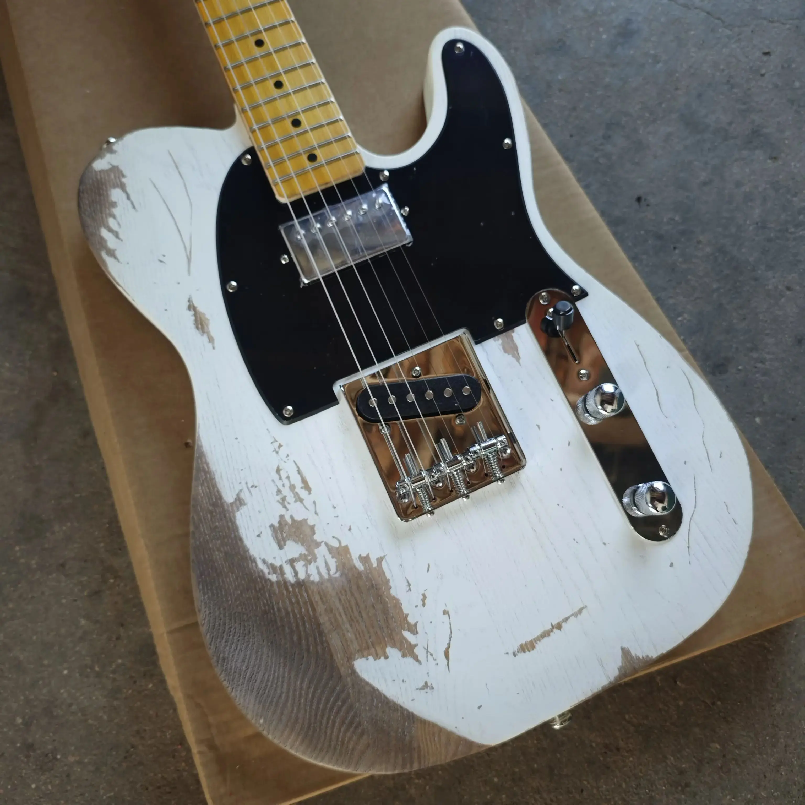 White six string electric guitar with distressed treatment, featuring a basswood body, maple neck, and black panel