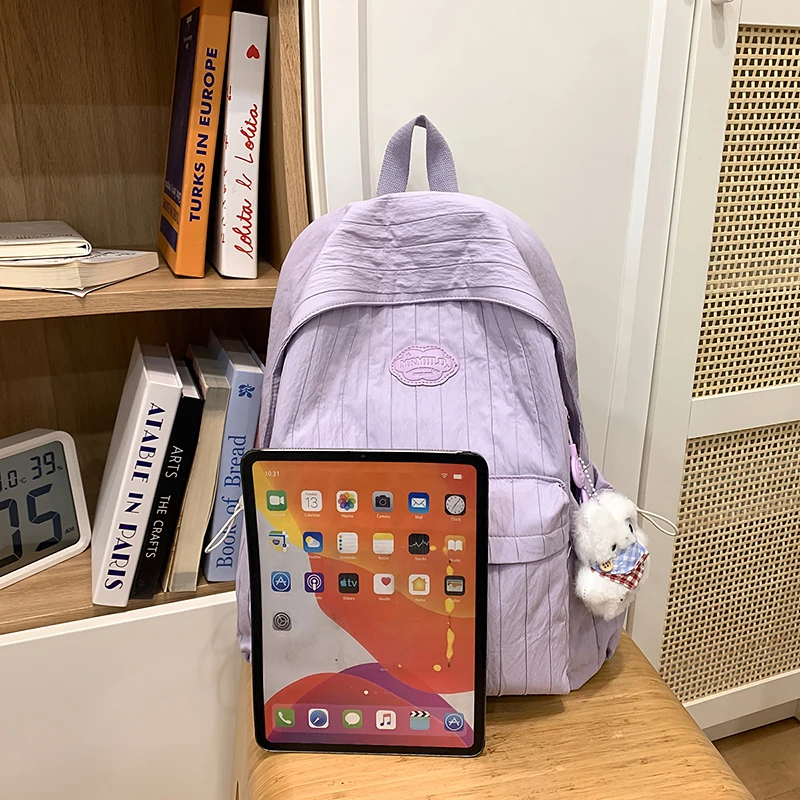 Coreano náilon mochila feminina casual cor sólida pequena mochila de viagem para adolescente mochila escolar com decoração boneca