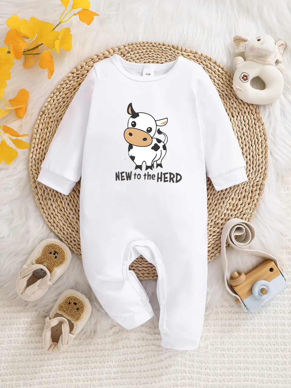 Ein langärmeliger Baby-Strampler mit interessanten Buchstaben-Prints. Es verfügt über ein Knopfverschluss-Design für einfaches An- und Ausziehen, und