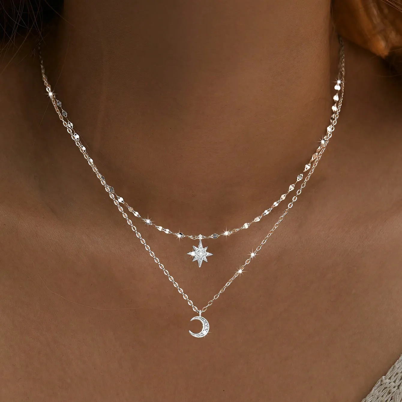 Delicate dual-layer pendant necklace featuring celestial motifs with minimalist star and crescent moon charms on a slender adjus