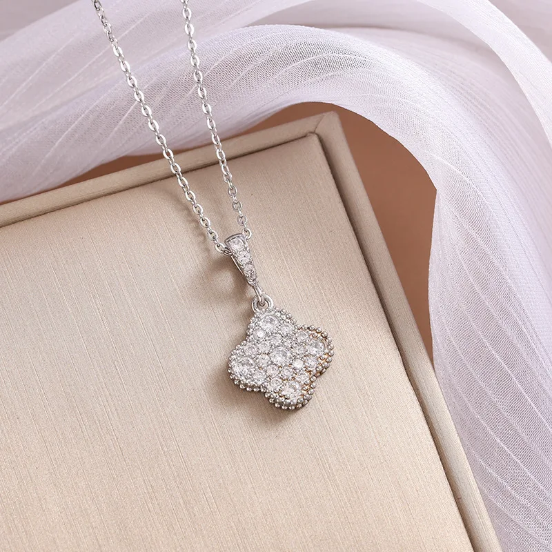 Um luxuoso trevo de quatro folhas de cobre incrustado de diamantes com um colar é streaming ao vivo por uma mulher