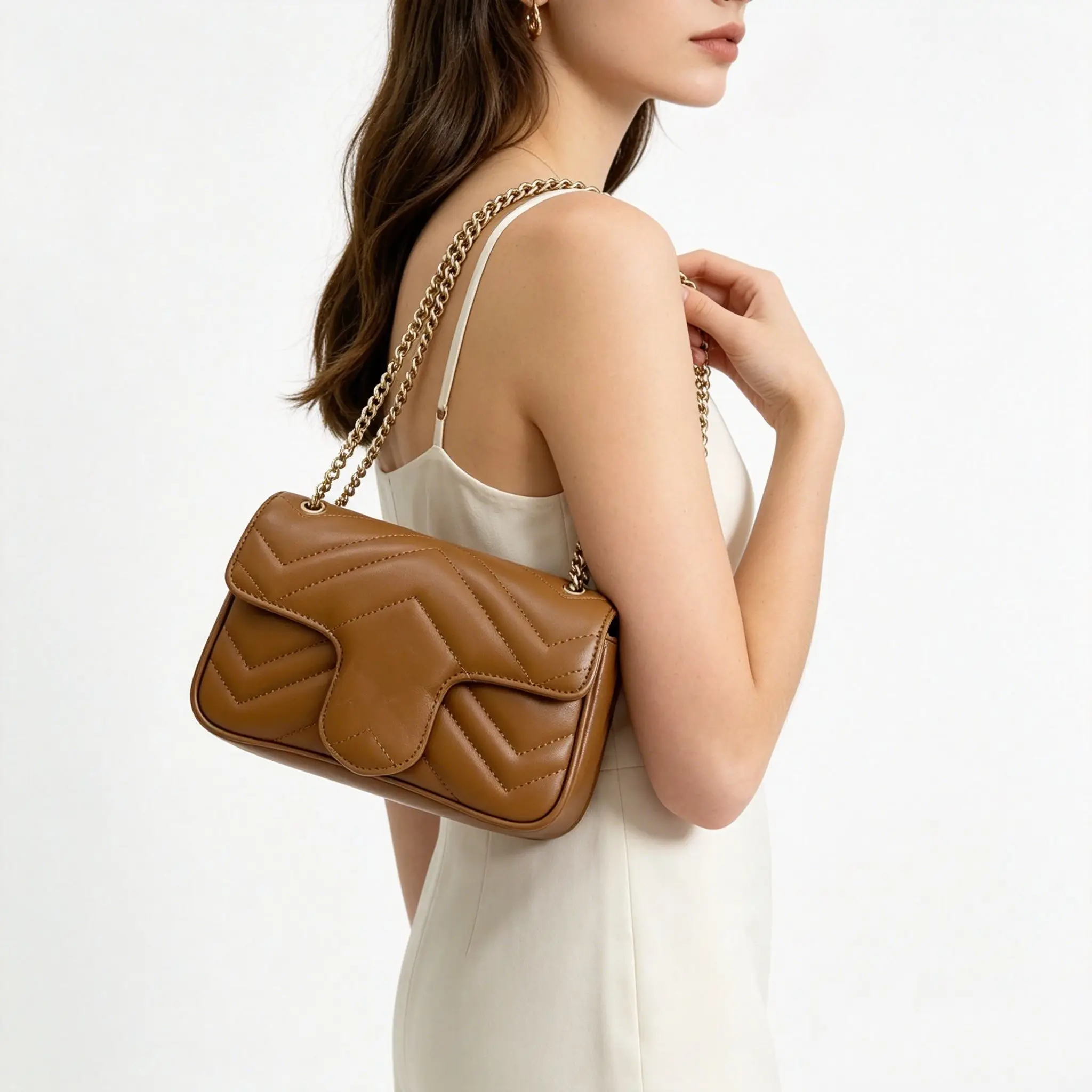 

Classic quilted leather shoulder bag in rich brown, featuring a herringbone stitch pattern, a signature curved flap, and a gold chain shoulder strap.