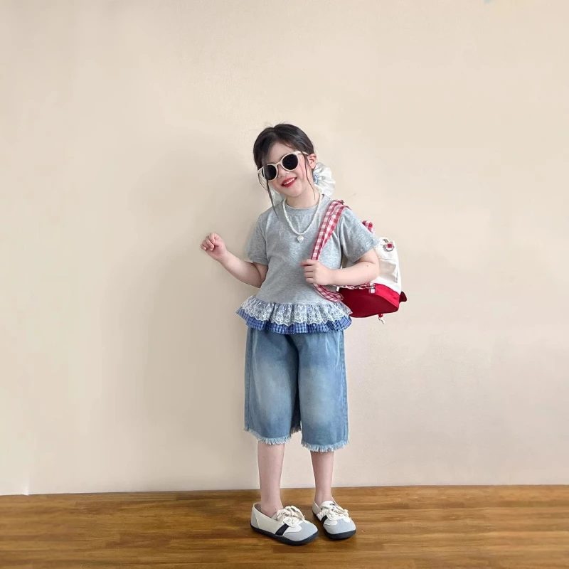 

Коллекция одежды: Летний комплект для девочек 2026 года – синий топ с кружевной отделкой и серыми джинсовыми шортами с рваным краем и оборками, с коротким рукавом