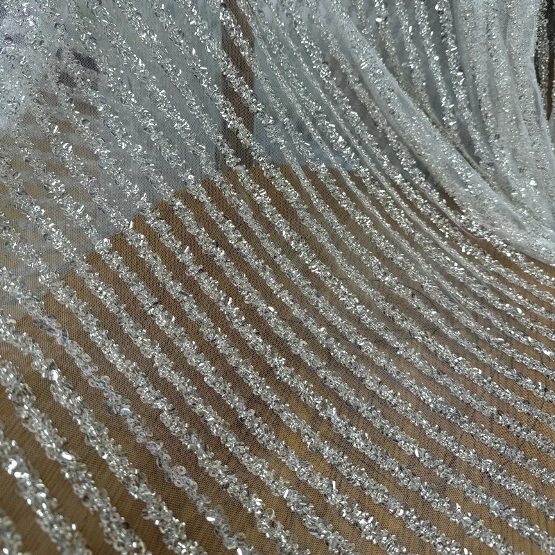 

This popular transparent mesh fabric that combines sequins, nail beads, and striped lace is the ideal fabric for wedding dresses