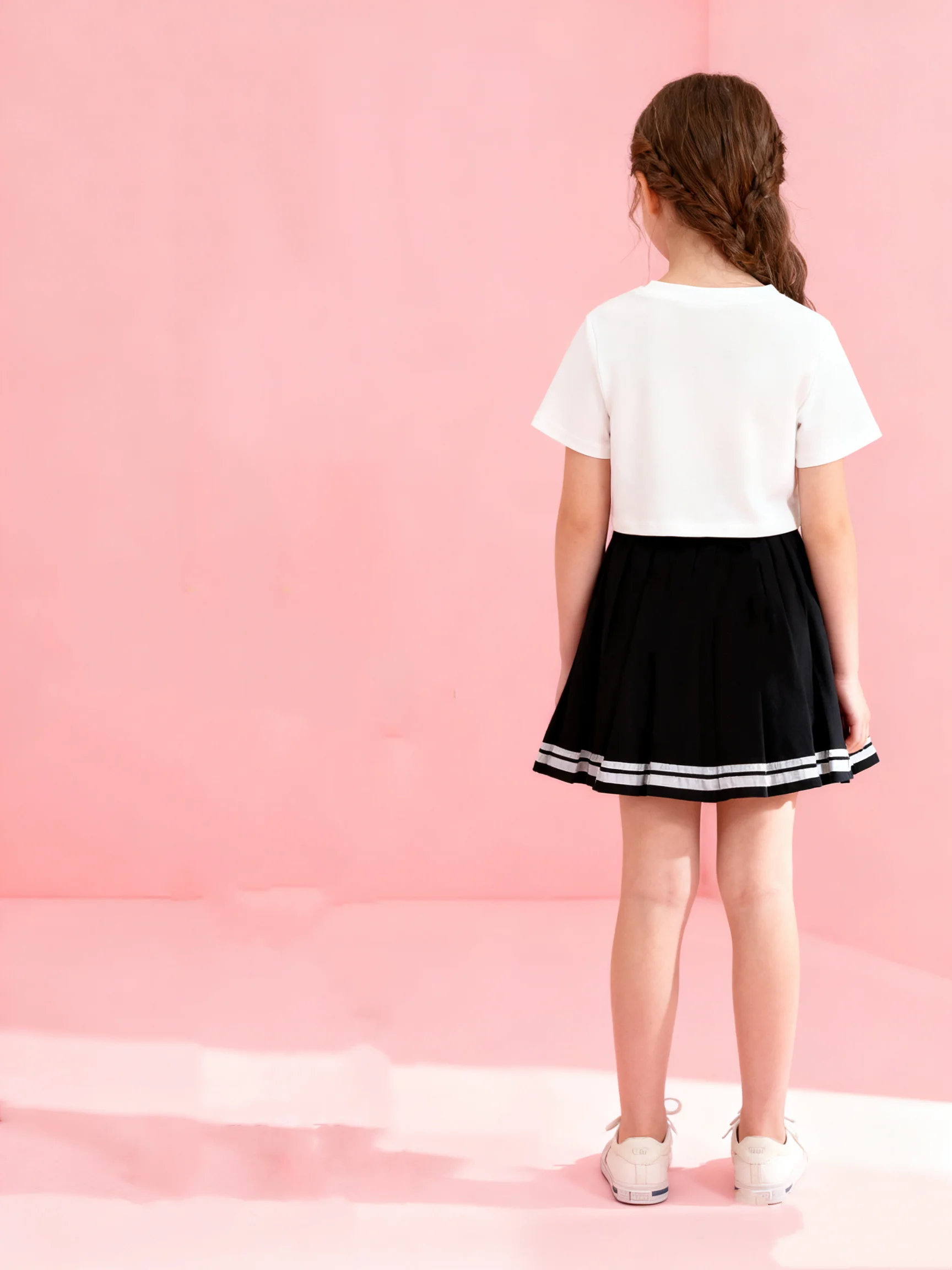 تي شيرت صيفي قصير للفتيات مكون من قطعتين برقبة دائرية ومطبوع عليه حروف بلون سادة وتنورة مطوية على طراز الكلية