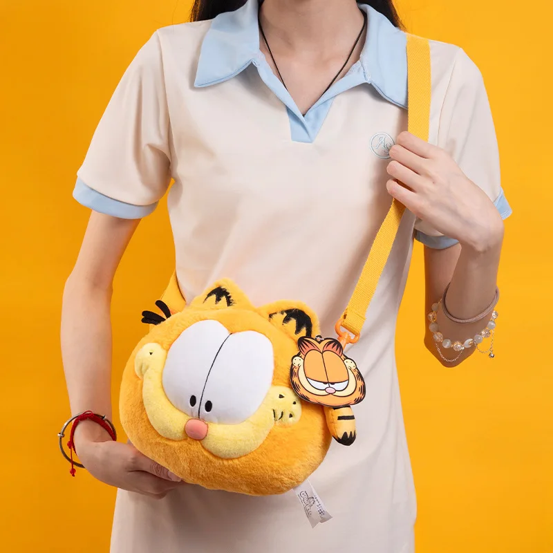 GARFIELD Original Plush กระเป๋าเป้สะพายหลังน่ารัก Garfield กระเป๋าสะพายเสื้อคลุมฮาโลวีน Mantle ตุ๊กตาการ์ตูนของขวัญวันเกิดเดียวกัน