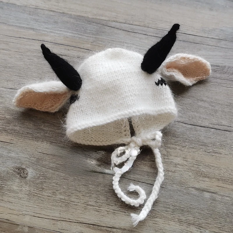 Newborn Baby with A Full Moon for 100 Days Takes Pictures of A Cow-shaped Hat Wrapped In A Cloth Towel.