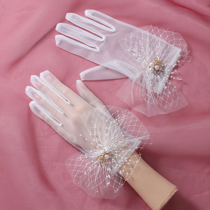 The bride's accessory is a pair of white minimalist bow decorated split finger gloves suitable for women's wedding parties